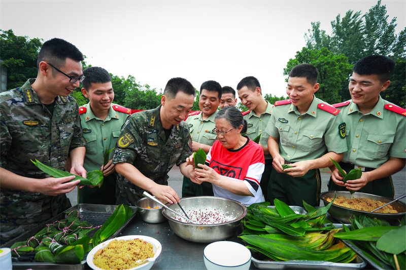 “兵妈妈”陈莉萍与武警官兵一起包粽子。郭传伍摄