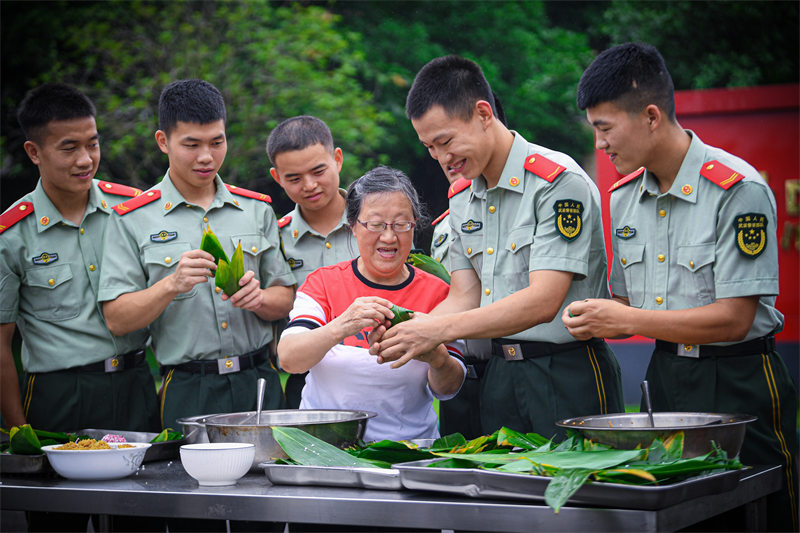 “兵妈妈”陈莉萍与武警官兵一起包粽子。郭传武摄