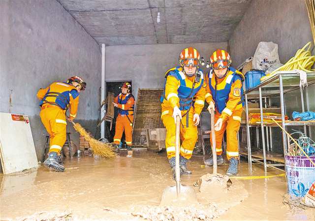 6月21日，南川区太平场镇桥头社区，应急管理局救援人员在帮助受灾群众清淤。通讯员 甘昊旻 摄/视觉重庆