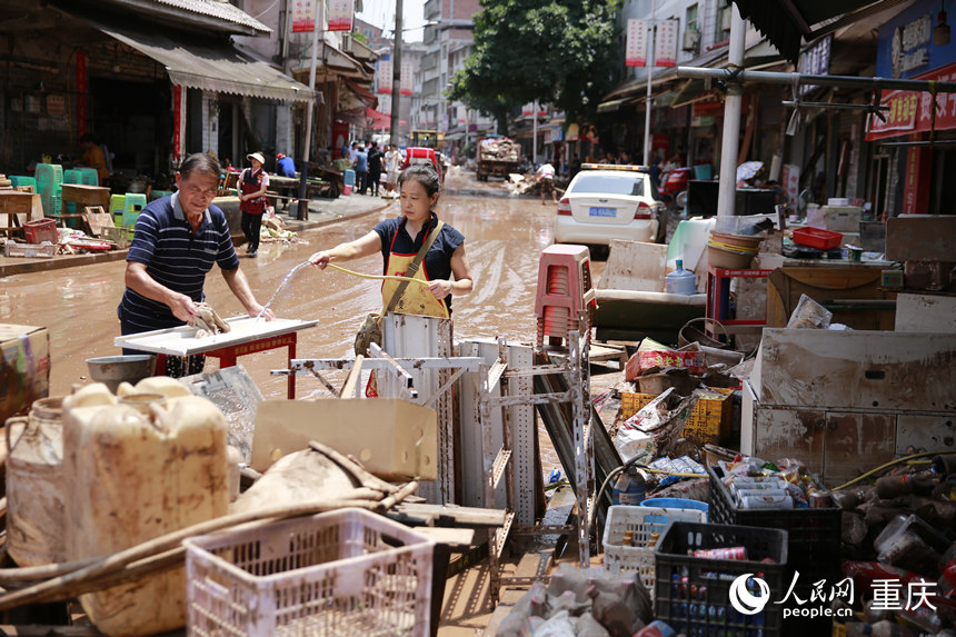 7月12日，洪水消退后，仁沙鎮居民正在清洗被洪水浸過的物品。人民網記者 劉政寧攝