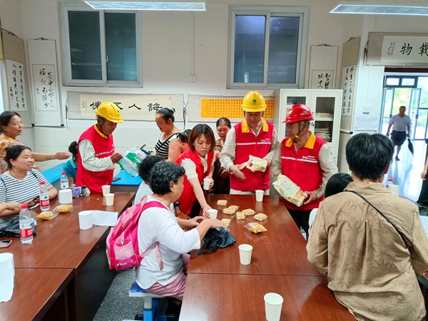 國家電網紅岩（榮昌）共產黨員服務隊隊員在吳家鎮中心小學應急安置點向群眾發放慰問食品。國網重慶永川供電公司供圖
