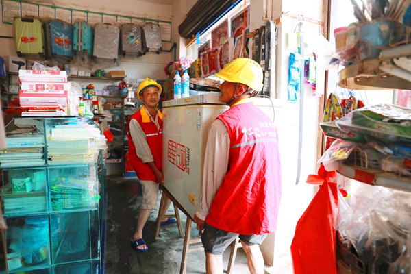 國網重慶永川供電公司員工在榮昌吳家鎮幫助受災群眾搬運冰箱到高處防止觸電事故發生。國網重慶永川供電公司供圖