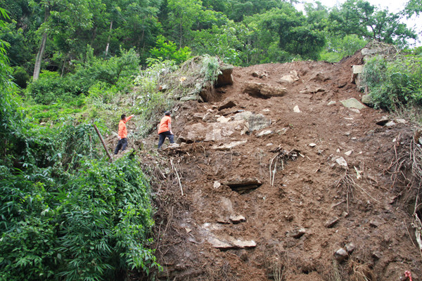 《陡坡上的抢险地质人》。6月29日，彭水一处公路边坡出现垮塌险情，驻守地质工程师李应平、王发英第一时间赶到现场登上陡坡开展应急调查。李明亮摄