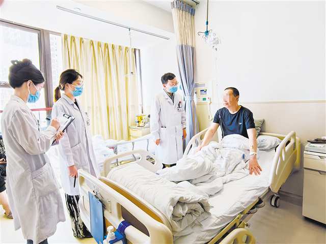 八月六日，重医附二院江南院区，血液内科主任医师罗云（右二）带着护士为安置在心血管科病房的患者检查病情。记者 李志峰 摄\视觉重庆