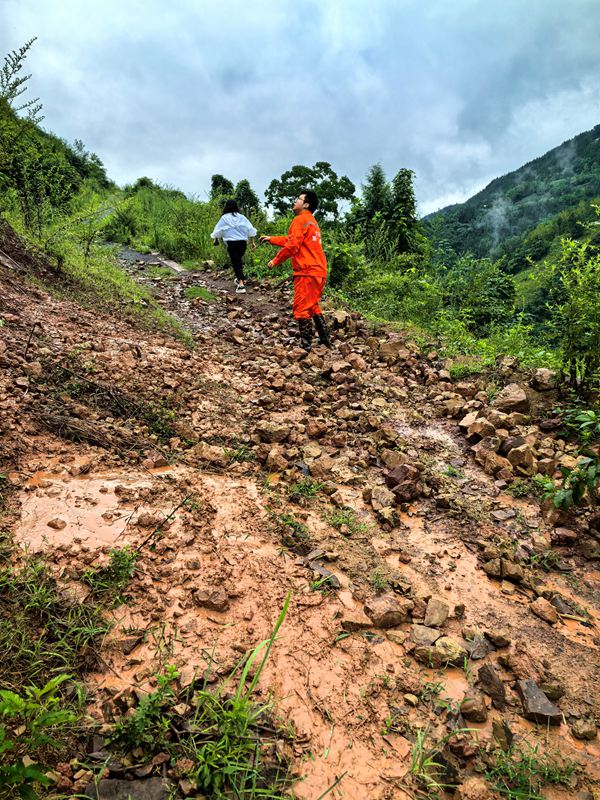 《雨后地灾巡查》。7月11日，巫山县铜鼓镇副镇长温利华、地质驻守工程师王忠凌（右）雨后巡查铜鼓村柏果树坪地灾点。刘勇摄