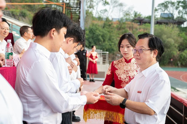 重庆理工大学党委书记康骞为新生代表颁发校徽。重庆理工大学供图