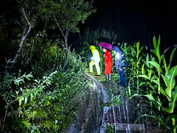 《雨中巡查滑坡点》。7月3日夜间，巫山县铜鼓镇下大雨，为保障群众生命财产安全，铜鼓镇副镇长、地质灾害防治“四重”网格化片区负责人刘勇（右一），带领铜鼓镇政法委员、人武部长欧云鑫（右三）及驻守铜鼓镇的地质工程师王忠凌（右二）雨中前往地灾滑坡点现场巡查。谢清艮摄