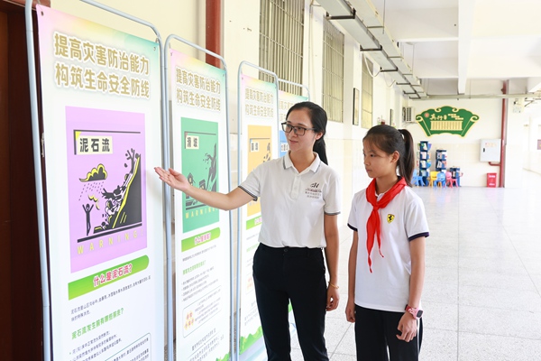 同学们在科普员的讲解下，观看展板、学习地质灾害防治知识。曾英豪摄