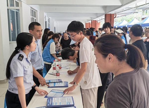 大足区税务人员向同学们讲解大学生医保相关政策。罗正玲摄