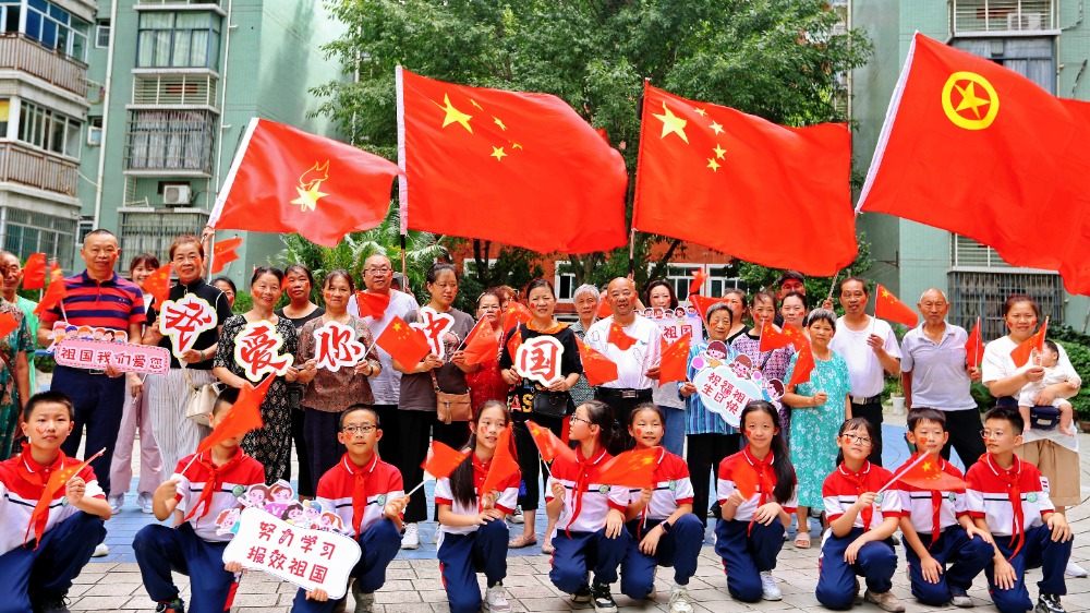 9月30日，万盛经开区万盛小学开展“厚植家国情怀 共庆祖国华诞”主题“快闪”活动。老师们带领同学们走进街道社区，与国旗合影，高唱《我和我的祖国》。通讯员 王泸州 摄