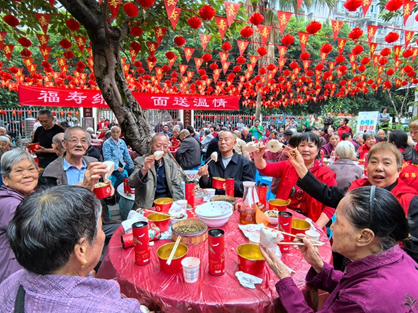 老人们开心的吃着社区准备的寿包。桃花桥社区供图