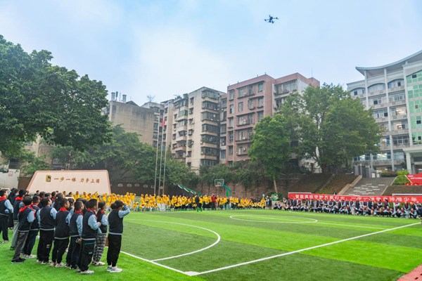 何涛在上游小学足球场为学生们演示无人机操作。国网重庆永川供电公司供图