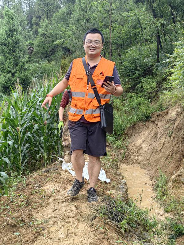 《欣慰》。7月14日，暴雨后，南江地质队驻守工程师粟思淋在巫山县建平乡核查地灾点。看到预防滑坡的排水沟起了作用，即便脚下是泥泞，心情也是愉悦的。吴叔刚摄