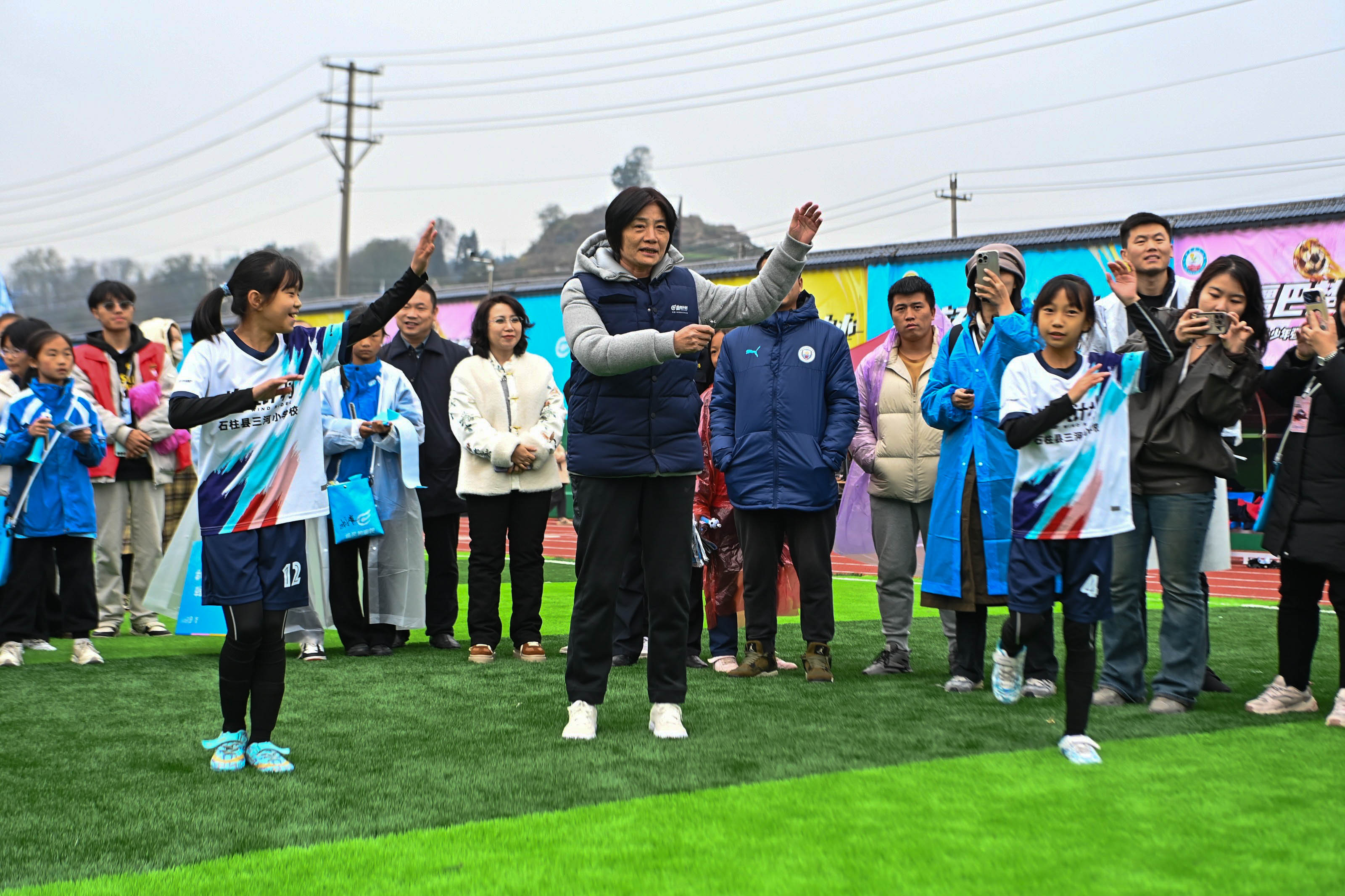 水庆霞教练和重庆石柱三河小学的队员们一起跳起摆手舞庆祝冠军。吴汪洋摄