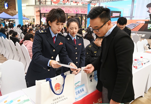 12月3日，渝中區稅務局聯合區司法局走進龍湖時代天街開展憲法宣傳活動，發放宣傳資料、解答涉稅費問題。徐佑君攝