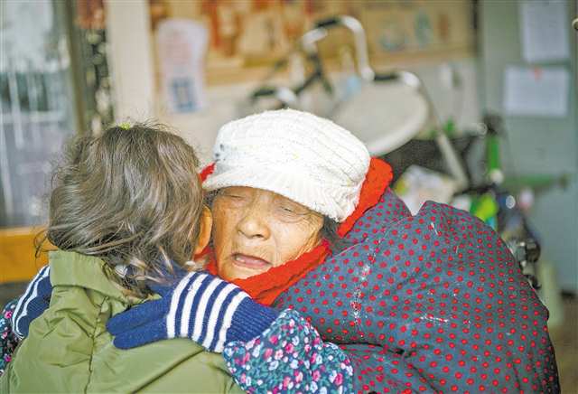 九龙坡区黄桷坪街道搬运东村，老人感动地抱住表演完节目后的小志愿者。（摄于2021年11月25日）通讯员 周舸 摄/视觉重庆