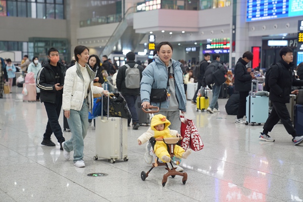 重慶火車北站候車廳內，旅客帶著行李踏上回家路。汪亮攝