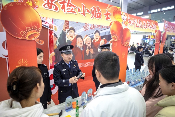 1月14日，重慶火車北站候車大廳，成都鐵路公安局重慶公安處民警向旅客宣傳安全乘車注意事項。胡勇攝