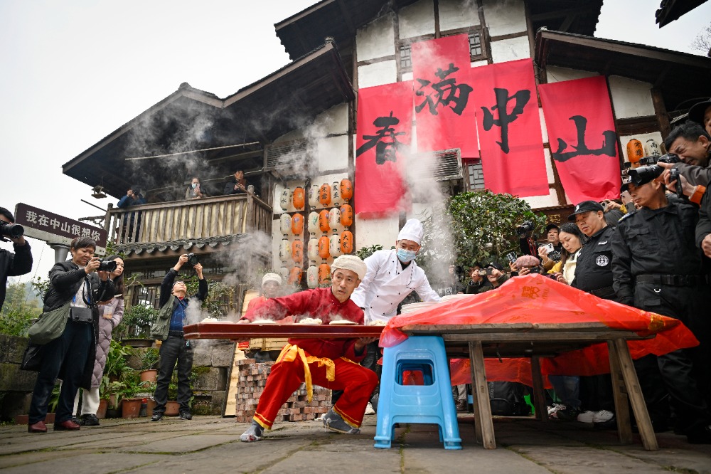 2025年1月18日，江津中山古镇，杨光祥在厨师帮助下将菜装入木托盘。记者 张春晓 摄