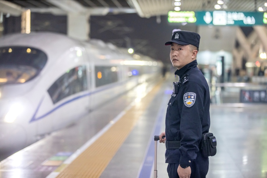 1月20日，在广州南站站台，乘警李镇等待G4616次列车进站。胡勇摄