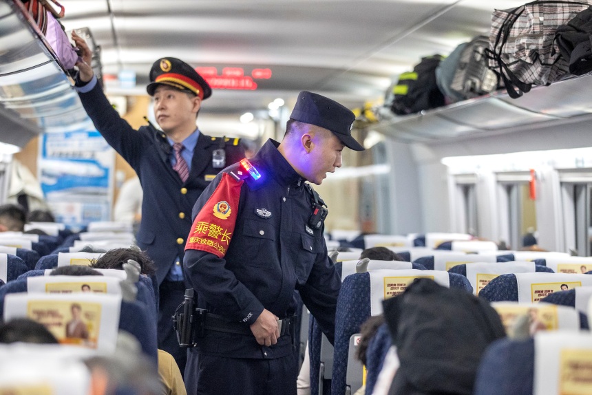 1月20日，在G4616次列车车厢，乘警李镇与列车长王家山对车厢进行巡视，并向旅客开展安全宣传。胡勇摄