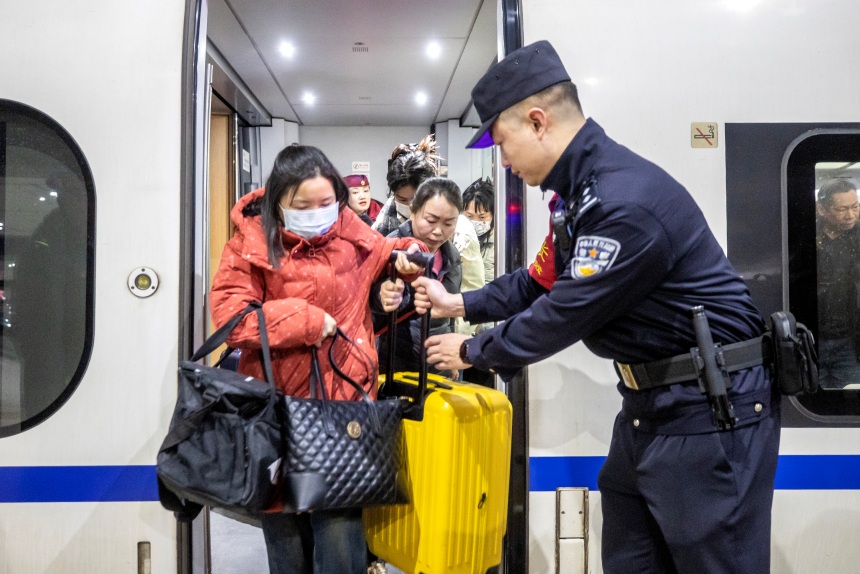 1月21日，G4616次列车抵达重庆西站后，乘警李镇在车门处引导旅客有序下车。胡勇摄