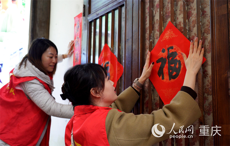 志愿者们为黄葛古道敦厚坡老街挂灯笼。人民网记者 刘祎摄