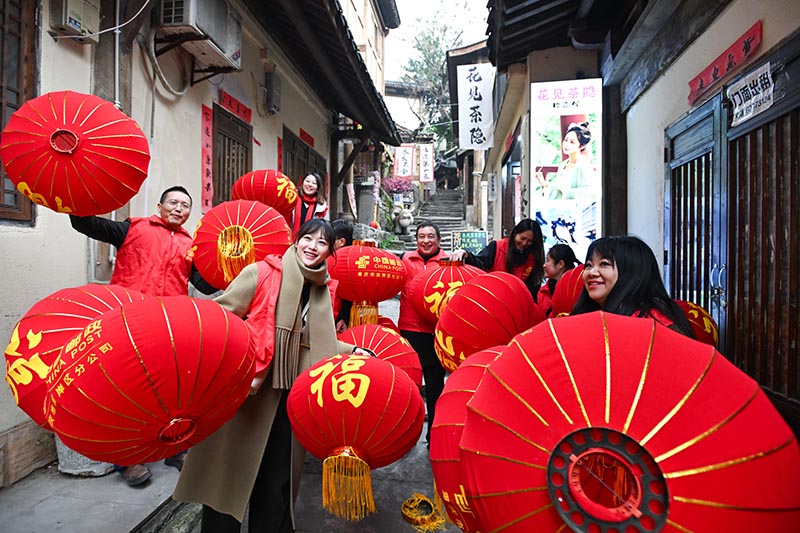 志愿者们为黄葛古道敦厚坡老街的传统民居挂灯笼。郭旭摄