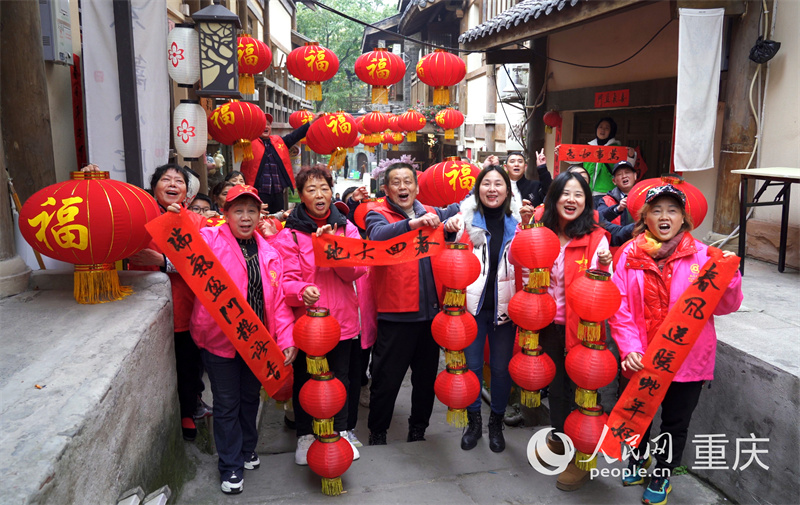 志愿者们为黄葛古道敦厚坡老街的传统民居贴春联。人民网记者 刘祎摄 