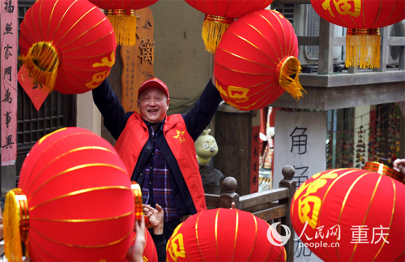 志愿者为黄葛古道敦厚坡老街的传统民居挂灯笼。