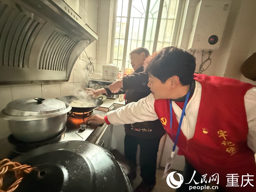 入户走访时，岳嬢嬢正在做饭，文登群赶紧去厨房调小燃气灶的火。人民网记者 胡虹摄