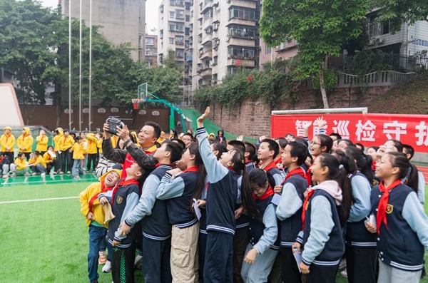 何濤（紅馬甲）為學生們展示無人機操作。國網重慶永川供電公司供圖