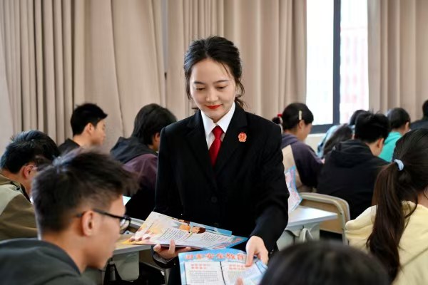 向學生們發放宣傳資料。主辦方供圖