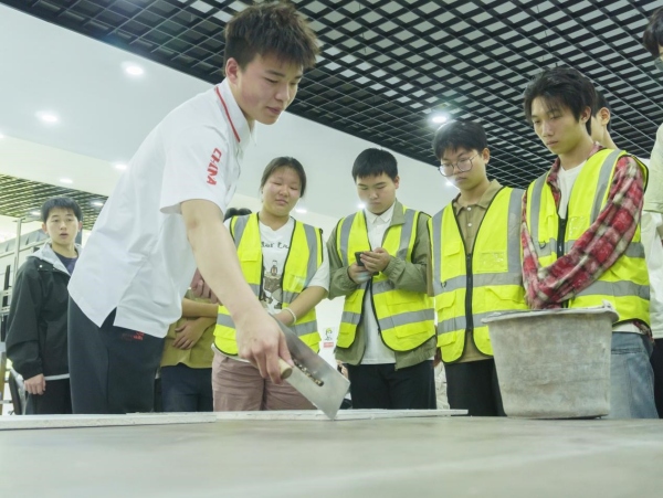 熊首鈺展示抹灰實操技巧。重慶工商職業學院供圖