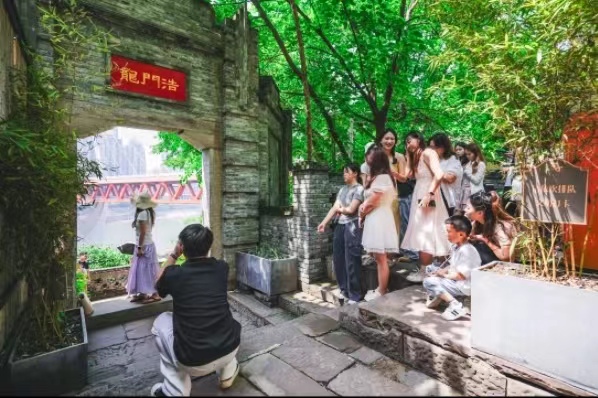 游客们在标志性景点拍照。龙门浩老街供图