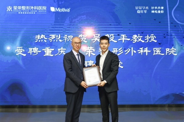 李昕昊（右）为特聘教授吴毅平颁发聘书。重庆星荣整形外科医院供图