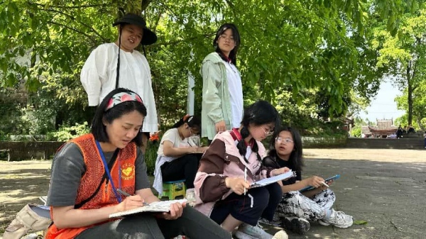 志愿者带领游客亲手描绘石刻。大足石刻研究院供图