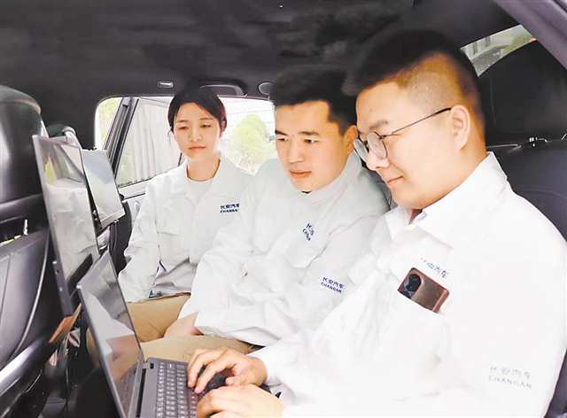 罗咏浩（右一）与团队成员一起上车测试。（受访者供图）