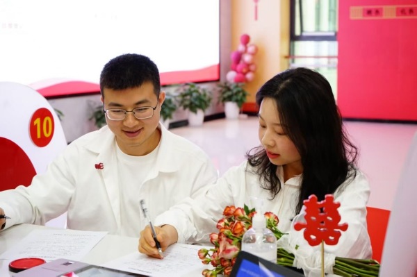 一对新人正在完成婚姻登记流程。徐梅摄