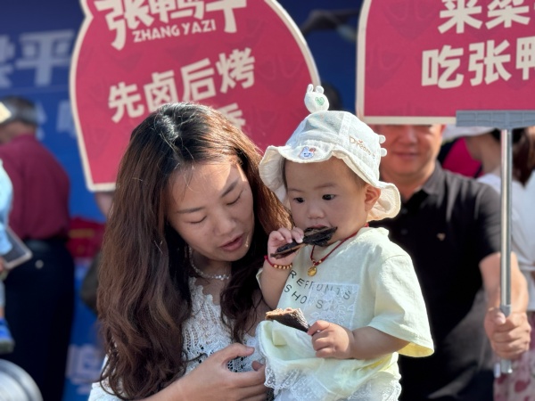 小朋友免费试吃卤烤鸭。陈俊摄
