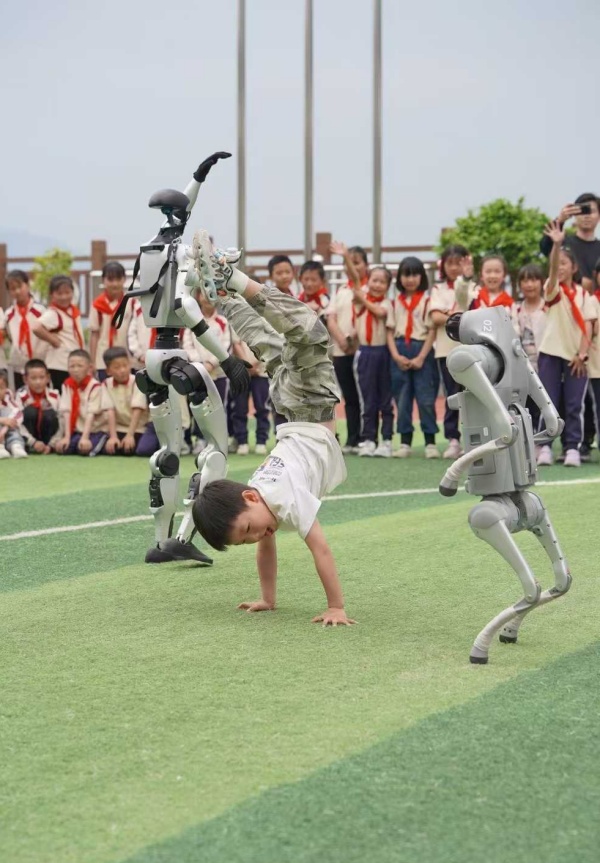 小朋友與機器人“斗舞”。甘國平攝