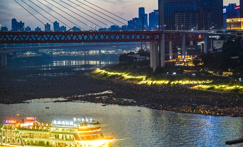 江北嘴江边，众多游客正在江滩上欣赏重庆美景。（资料图片）记者 郑宇 摄