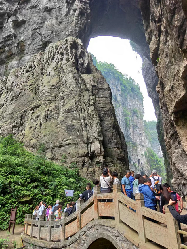 游客在天生三桥摄影留念。武隆喀斯特旅游公司供图