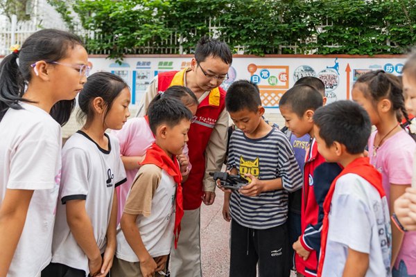 青年志願者指導學生們體驗無人機操作。國網重慶永川供電公司供圖