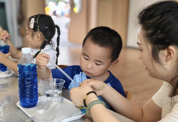 孩子们在老师的指导下做实验。悦来幼儿园供图