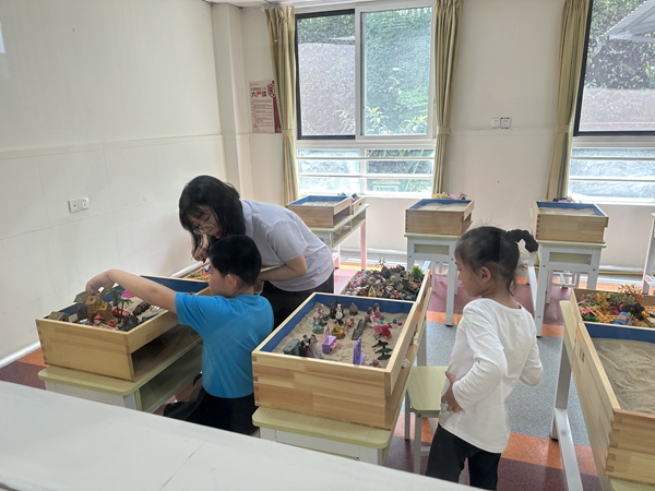 在沙盘融合教室，专业教师正对孩子们进行心理、情绪和语言等干预训练。荚天宇摄