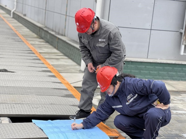 國網重慶經研院技經中心員工正在測量站內電纜溝尺寸。國網重慶經研院供圖