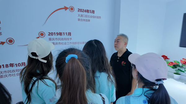 梅明向學生講述梅明社會工作服務中心的發展歷程。重慶理工大學供圖