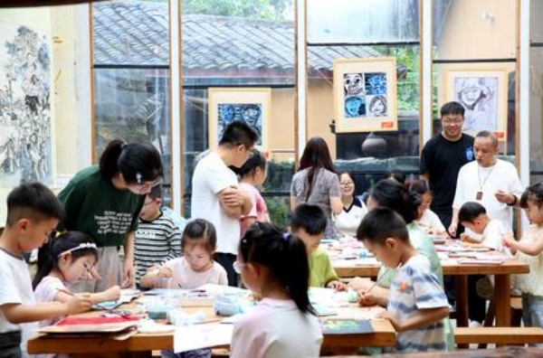 孩子们在大学生志愿者的指导下制作版画。张梦寒摄