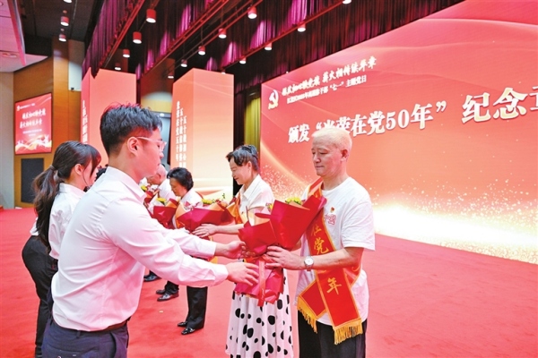 为“光荣在党50年”老党员献花。林豪摄
